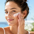 thumbnail image woman applying suncreen to face